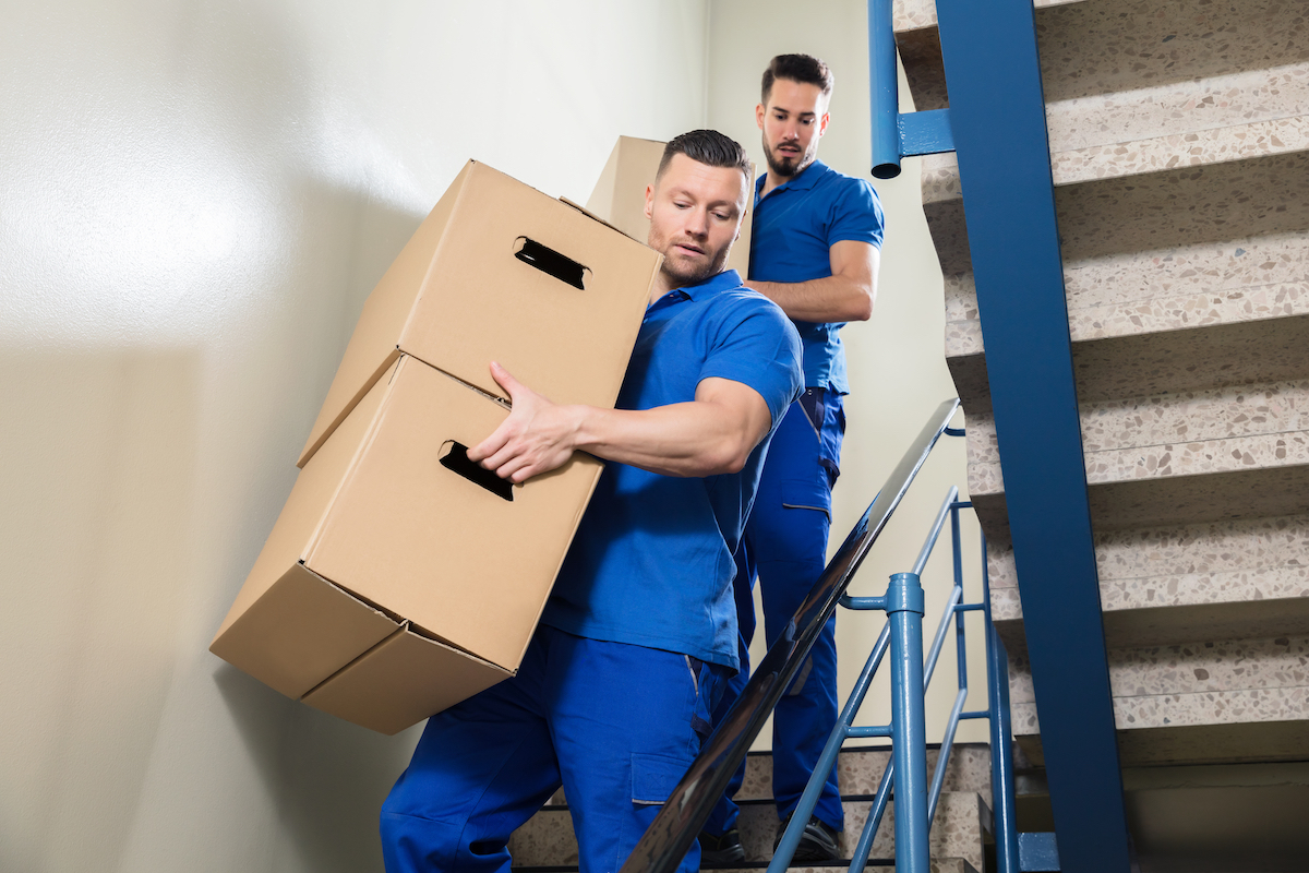 Carrying Up Stairs & Keeping Your Workers Safe on the Job 3 two men holding boxes while walking down stairs