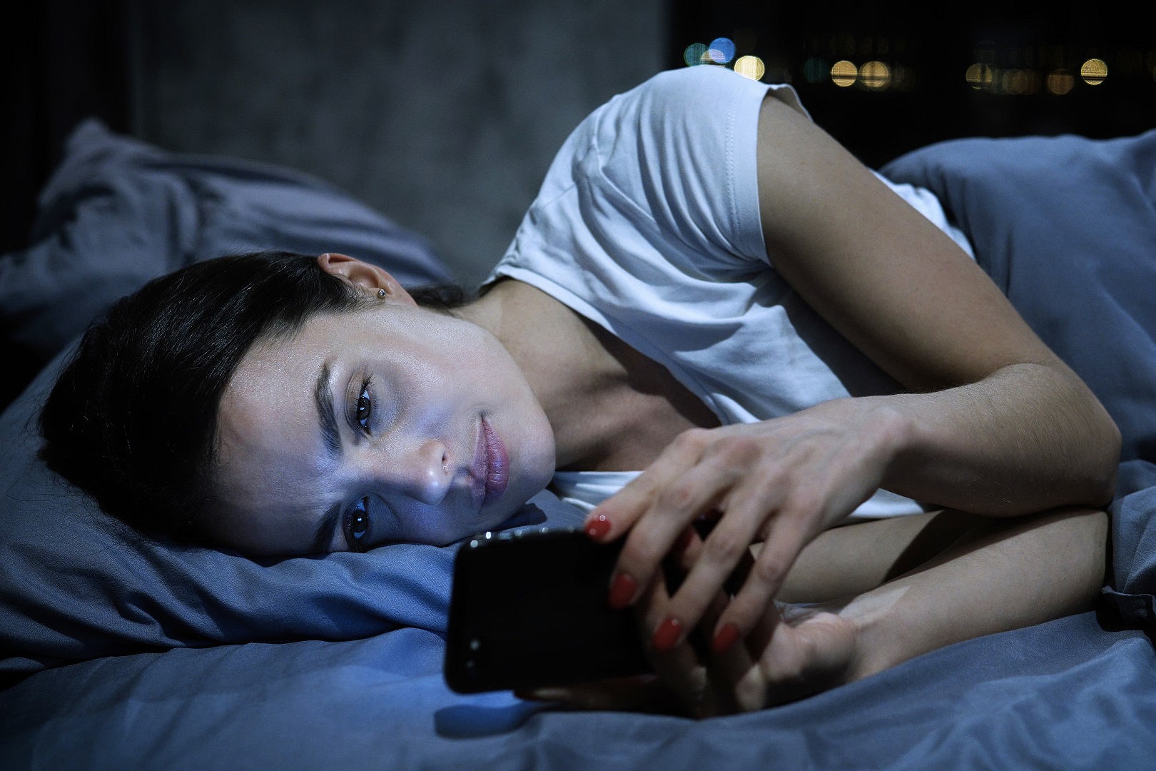 girl in bed on her phone
